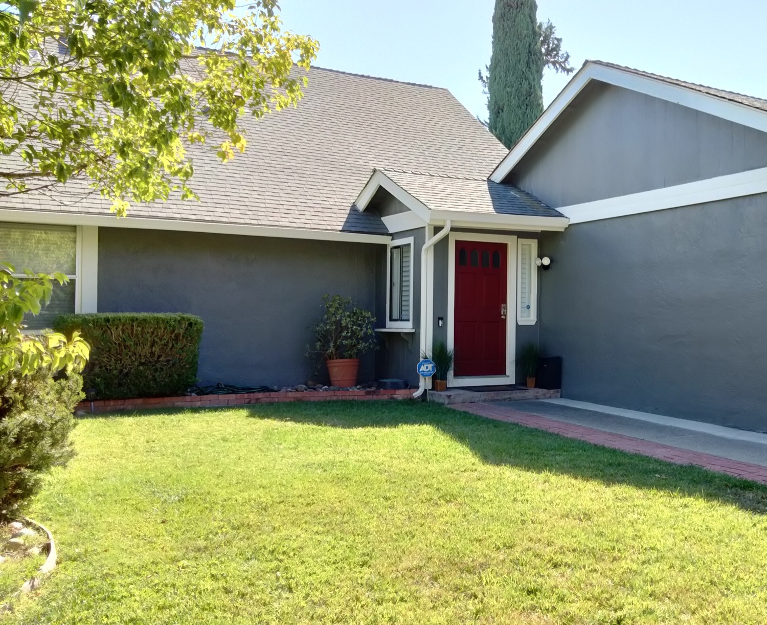 Repainted home exterior in Concord, with blue-gray siding, white trim, and a red entry door.