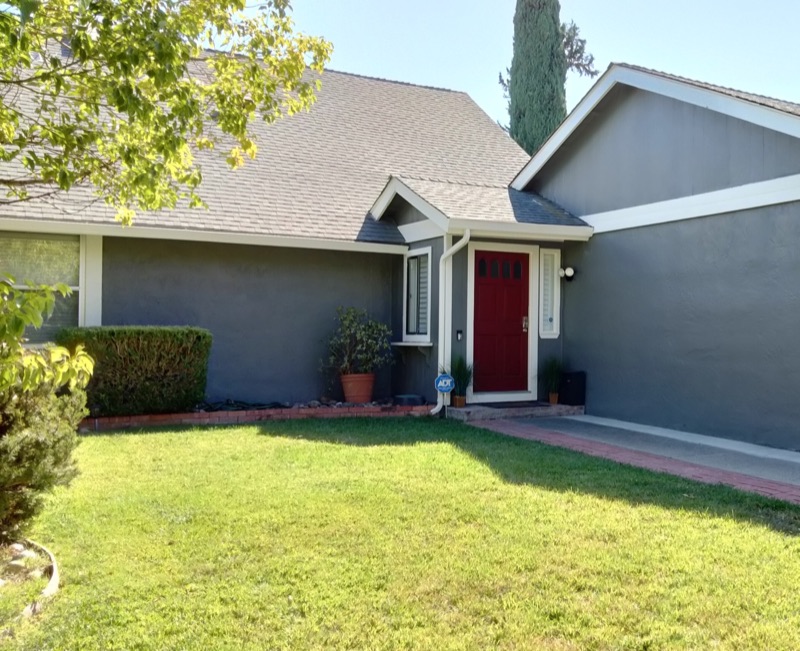 Repainted home exterior in Concord, with blue-gray siding, white trim, and a red entry door.