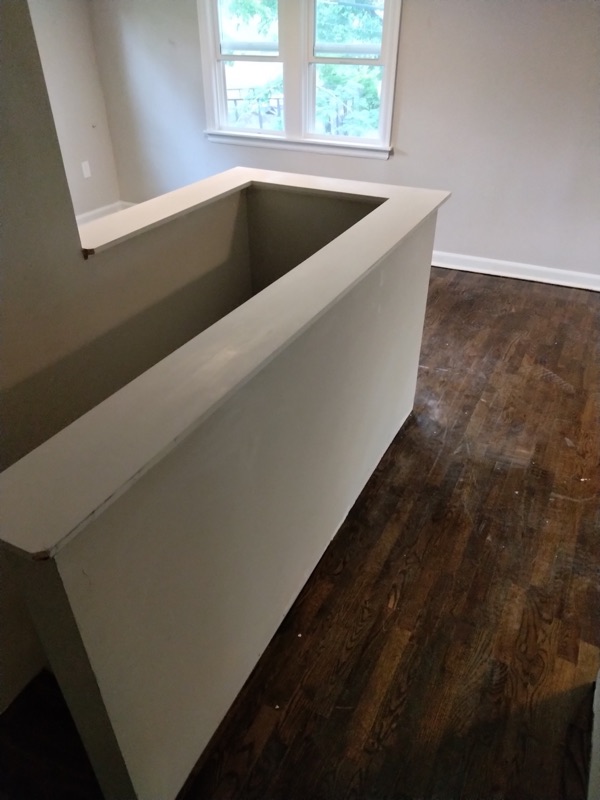Custom rebuilt interior half-wall beside a staircase.